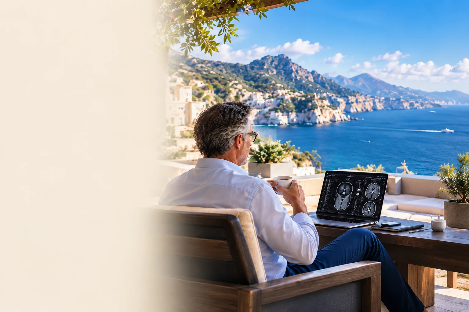 Radiologist at a workstation overlooking a broad blue coastal landscape.